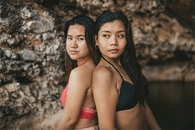 Dos chicas apoyadas por la espalda
