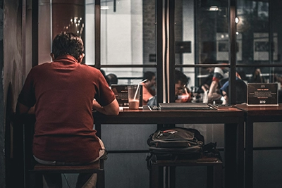 Un hombre solo des espaldas sentando en un bar