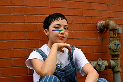 mujer con un arcoiris pintado en la cara